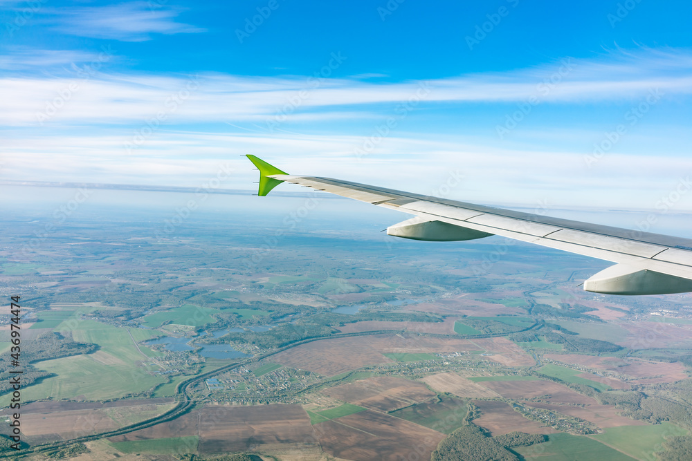 View of airplane wing, blue skies and the land during landing in Moscow, Russia. Airplane window view. View of airplane wing, blue skies and the land during landing in Moscow, Russia. Airplane window view.