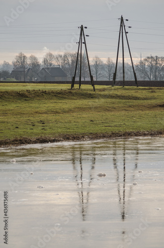 Reflection of electric poles in water.
