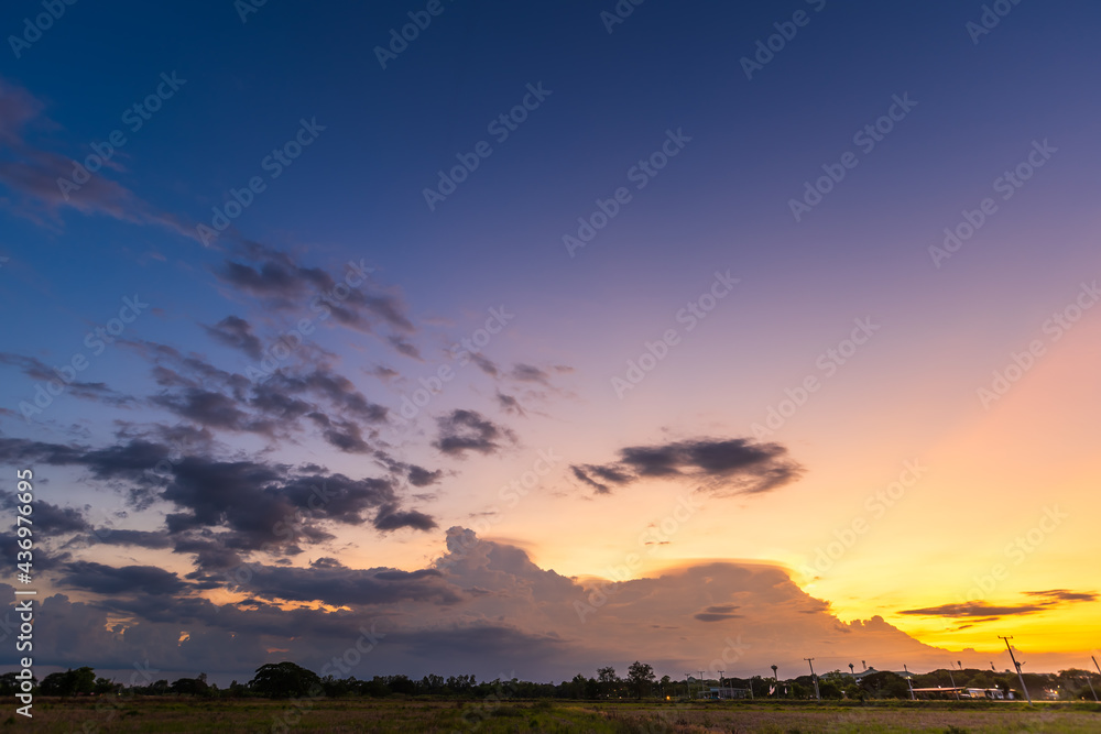 Twilight blue bright and orange yellow dramatic sunset sky in countryside or beach colorful cloudscape texture with white clouds air background. Twilight blue bright and orange yellow dramatic sunset sky in countryside or beach colorful cloudscape texture with white clouds air background.