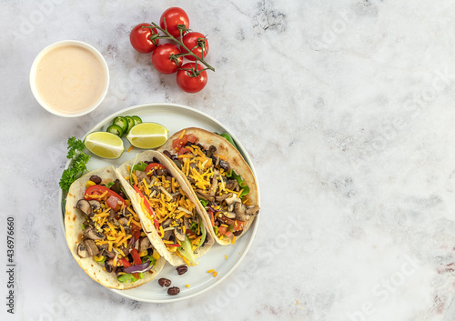 Vegetarian tacos with mushrooms, beans, peppers, and sauce. Traditional mexican food, top view, copy space.