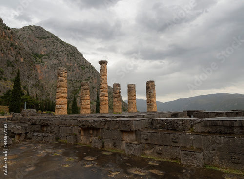 Panoramic view on Temple of Apollo  in Delphi against the background of mountains and the sky with clouds in Greece photo