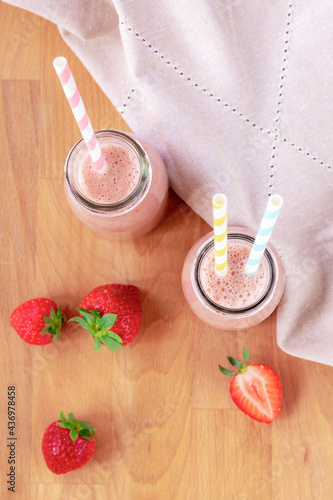 Strowberry smoothies on a wooden table. Healthy vegan food. Top view, flat lay photo