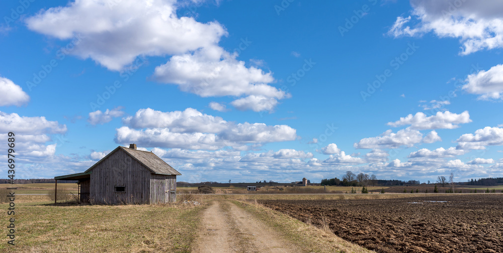 An old abandoned small wooden house in the field blue sky white clouds, barn or scary concept. An old abandoned small wooden house in the field blue sky white clouds, barn or scary concept.
