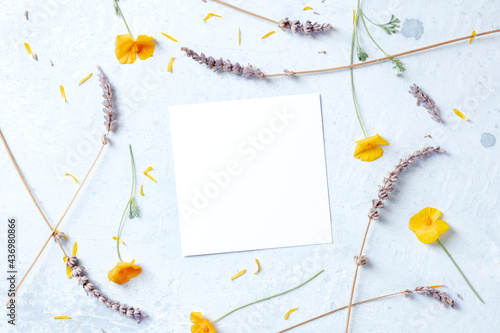 Spring wedding invitation or birthday postcard stationery mockup with a square card and flowers, overhead flat lay shot. A Mother's Day or Women's Day design layout photo