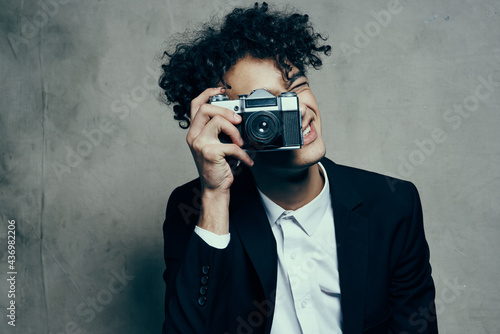 photographer with a camera in a classic suit curly hair Studio Model