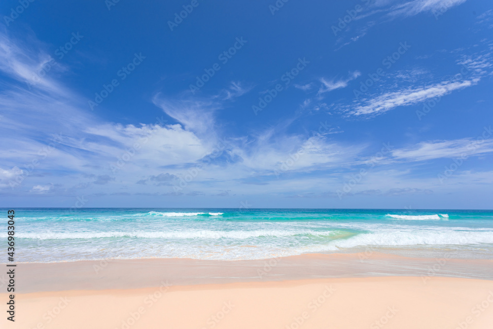Empty sea with white sand, undulating waves cover the beach on a sunny day. Overlooking the horizon and the clouds with blue sky. Tropical beach in the summer of Phuket Island, Thailand.