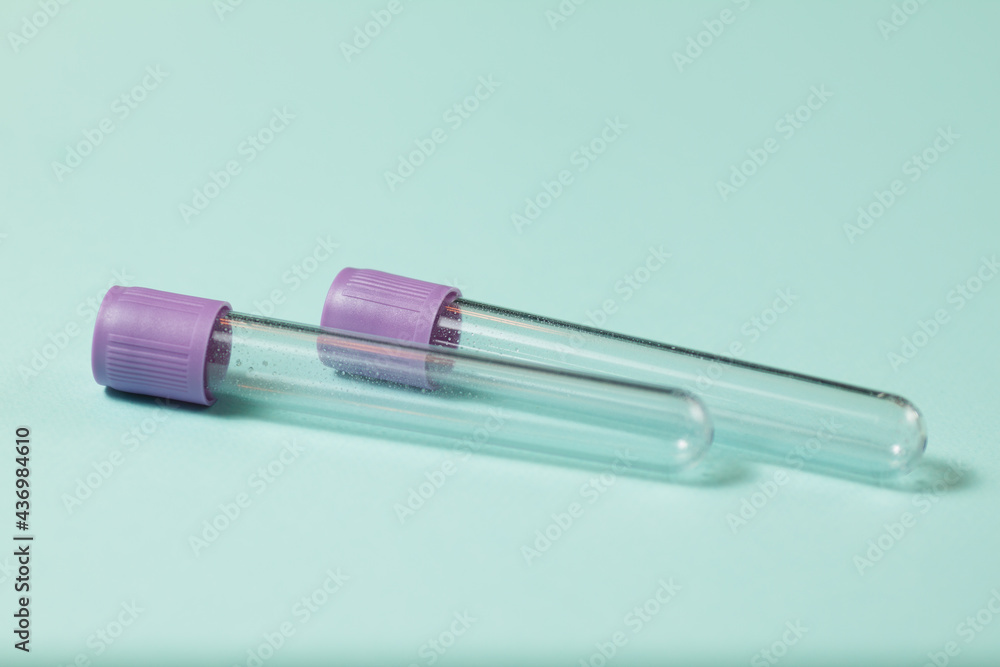 Purple empty vacuum blood collection tube test with EDTA as anticoagulant for Medical laboratory on turquoise background. Purple empty vacuum blood collection tube test with EDTA as anticoagulant for Medical laboratory on turquoise background.