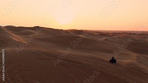 AERIAL. ATV travelling in sand desert. © skymediapro