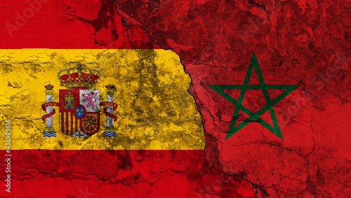 Concept of the Conflict and the Relations between Spain and Morocco with painted flags on a wall with a crack