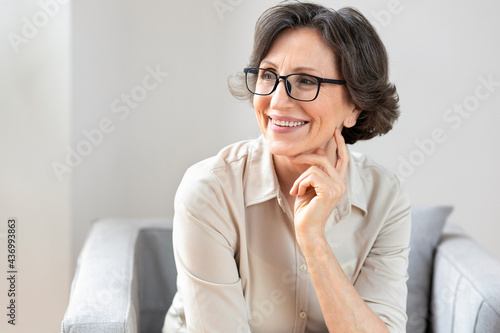 Portrait of smiling middle aged woman in glasses, copy space photo