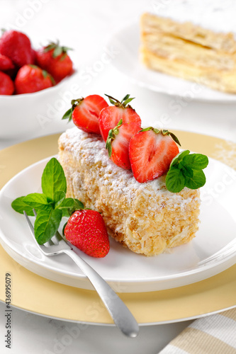 A slice of Napoleon cake with strawberries and mint. Russian cuisine  layer cake with cream  close up. Vertical orientation.