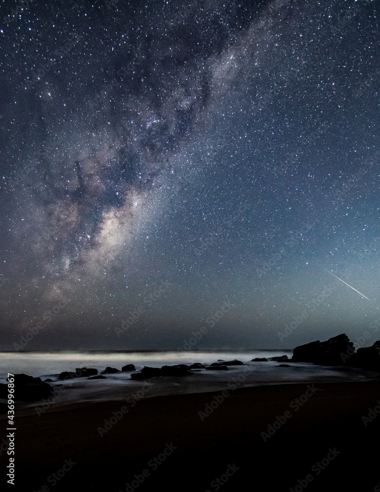 Milkyway seascape with rocks and shooting star