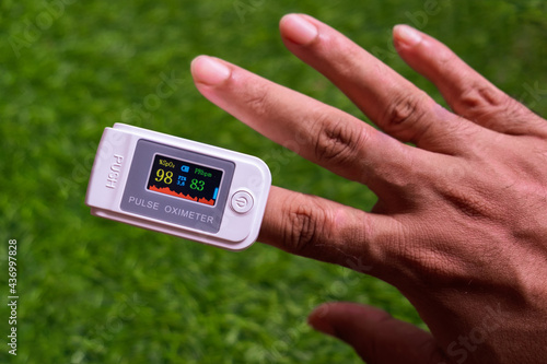 Man checking oxygen saturation popularly known as SpO2 and heart rate using a Fingertip Pulse Oximeter