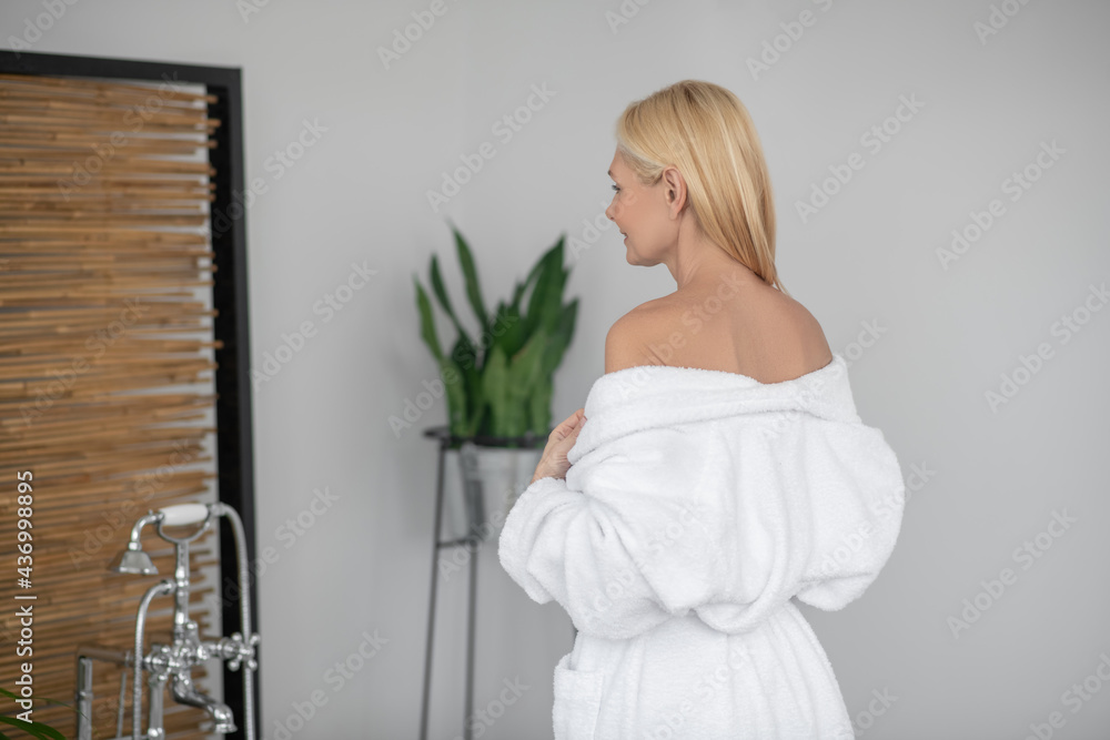 Pretty woman in a white robe with naked shoulders Pretty woman in a white robe with naked shoulders