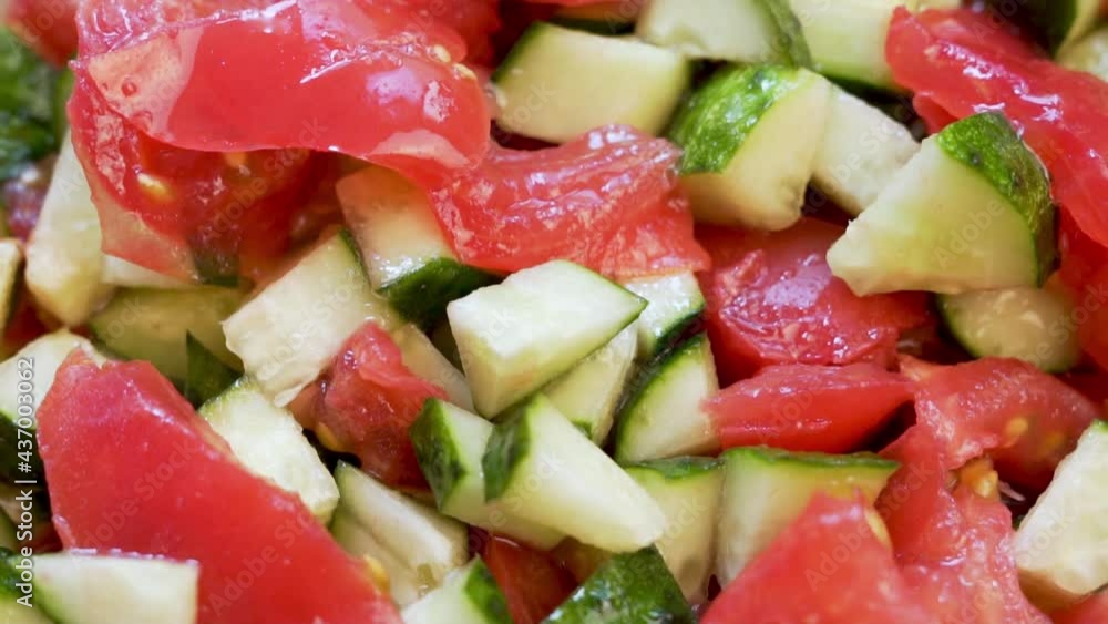 Slices Of Delicious Ripe Chopped Vegetables, Tomatoes and Cucumbers, Vegetable Salad Dressed With Olive Oil, Summer Vegetables, Close-up, Rotation. Isolated Background of Tomato and Cucumber Salad. Slices Of Delicious Ripe Chopped Vegetables, Tomatoes and Cucumbers, Vegetable Salad Dressed With Olive Oil, Summer Vegetables, Close-up, Rotation. Isolated Background of Tomato and Cucumber Salad.