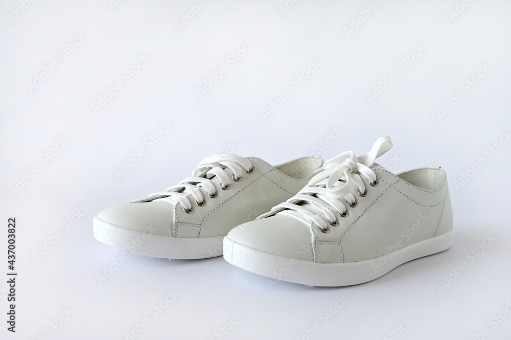 White summer women's sports shoes, stylish leather sneakers isolated on a white background. Advertising fashion shoes. Copy space White summer women's sports shoes, stylish leather sneakers isolated on a white background. Advertising fashion shoes. Copy space