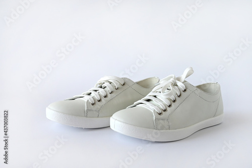 White summer women's sports shoes, stylish leather sneakers isolated on a white background. Advertising fashion shoes. Copy space