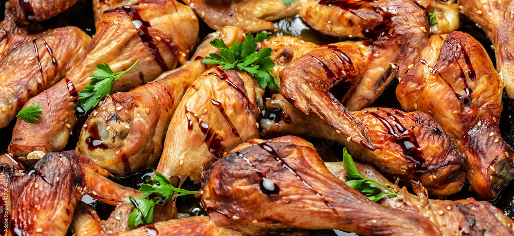 Close up of fried Baked chicken wings and legs. Long banner format, top view