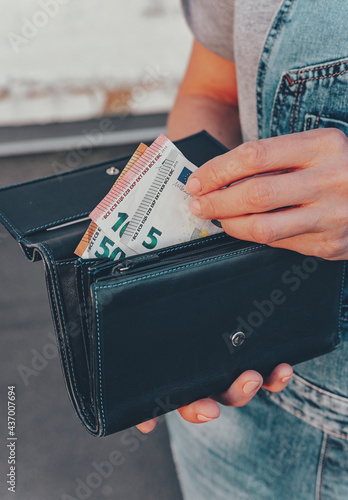 Female hands hold a wallet with euro banknotes. The concept of finance, savings, financial expenses. Close-up. Vertical shot