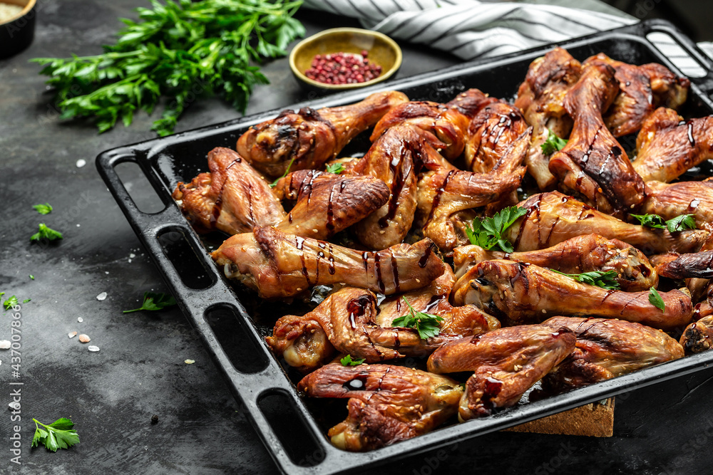 Chicken wings and legs with sauce. Wings of barbecue on dark stone table. Top view, Food recipe background. Close up Chicken wings and legs with sauce. Wings of barbecue on dark stone table. Top view, Food recipe background. Close up