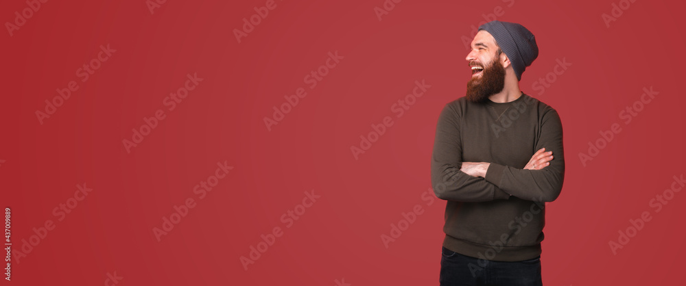 Photo of amazed bearded hipster man with crossed arms and looking away Photo of amazed bearded hipster man with crossed arms and looking away