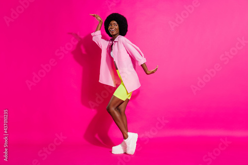 Photo of sweet funky dark skin woman dressed crop top smiling dancing isolated pink color background © deagreez