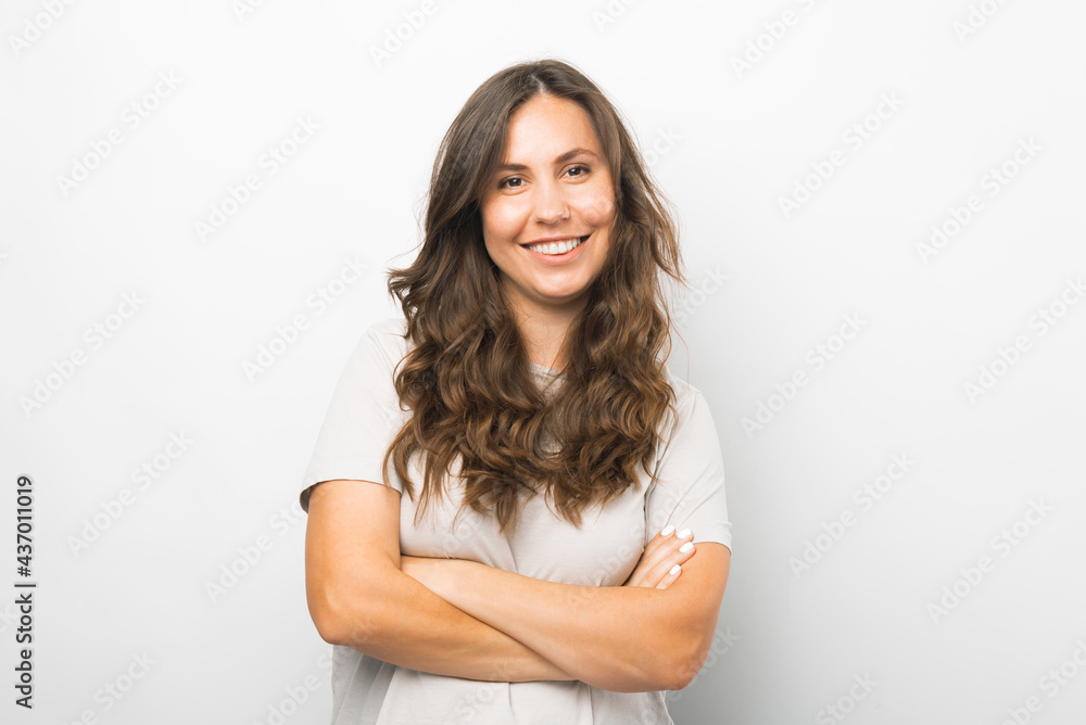 Portrait of young woman with crossed arms smiling and looking at camera Portrait of young woman with crossed arms smiling and looking at camera