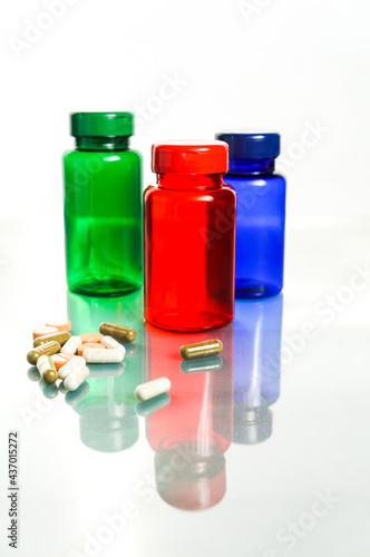 colorful bottles with pills over white background
