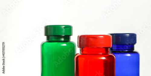 colorful bottles with pills over white background