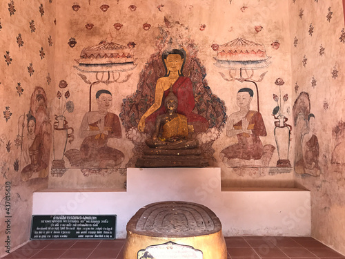 Trat, Thailand - December 20, 2020:  Mural painting and four Buddha footprints stacked together in the sanctuary of Buppharam temple (Wat Buppharam or Wat Plai Khlong) in Trat, Thailand. photo