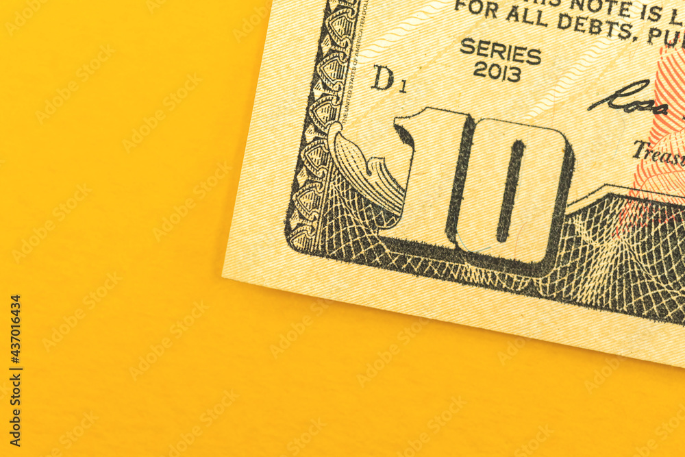 Deposit of small amount of money, ten dollar bill close-up on a yellow background, top view photo Deposit of small amount of money, ten dollar bill close-up on a yellow background, top view photo