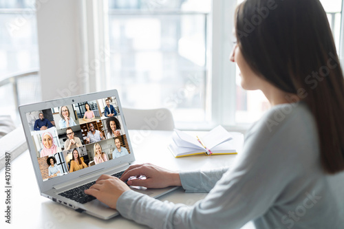 Female freelancer talking online with group of diverse colleagues or classmates, woman participates in video conference with multiracial team, virtual meeting on the laptop, e-learning