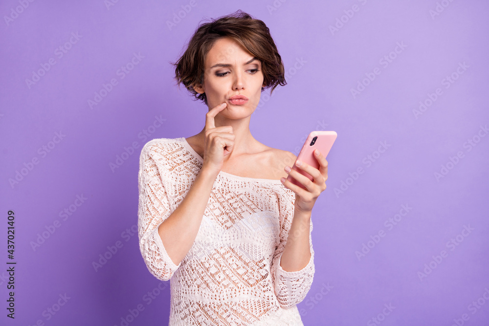 Portrait of pretty minded lady finger on chin look interested phone thinking isolated on purple color background Portrait of pretty minded lady finger on chin look interested phone thinking isolated on purple color background