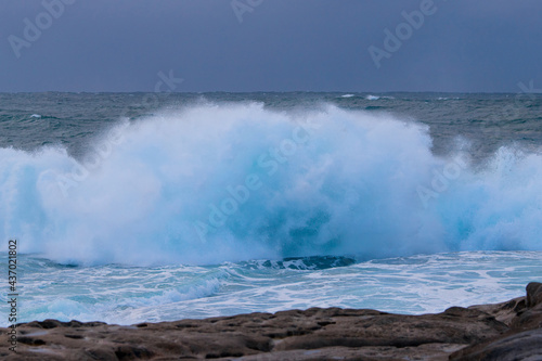 Big wave breaking into water spray on the coast. © AlexandraDaryl