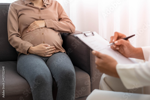 The pregnant mother is discussing depression symptoms during pregnancy with a specialist doctor or psychiatrist. The future mom is unhappy, worried, and stressed. Mental health concept