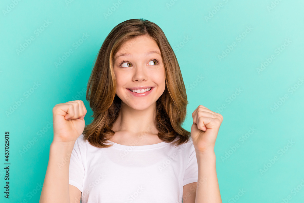 Photo portrait little girl happy gesturing like winner curious looking empty space isolated vivid turquoise color background Photo portrait little girl happy gesturing like winner curious looking empty space isolated vivid turquoise color background