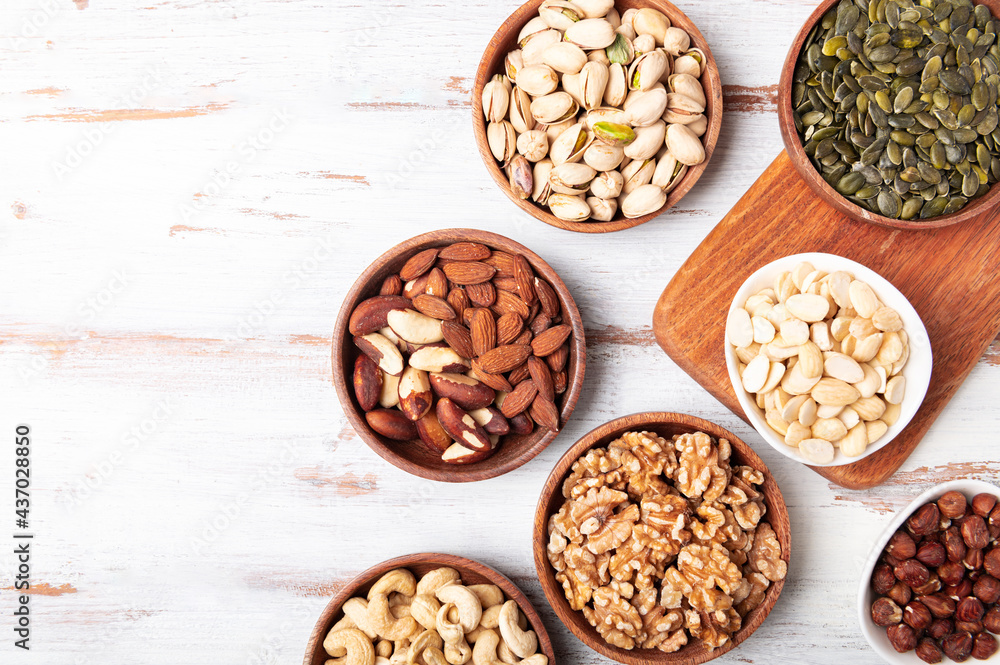 Different kind of nuts in wooden bowls Different kind of nuts in wooden bowls