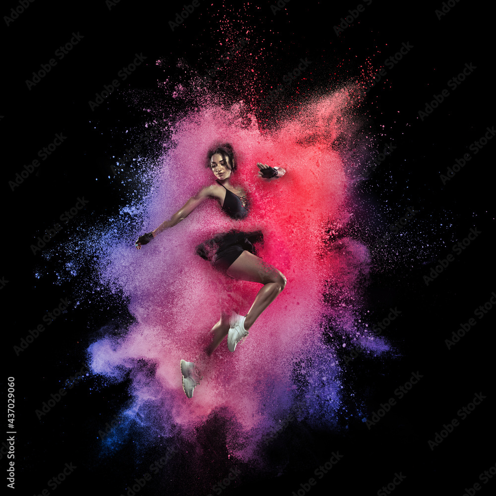 Young sportsman, female athlete running in explosion of colored powder ...