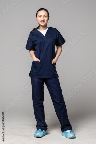 Full length of an Asian nurse standing against isolated white background