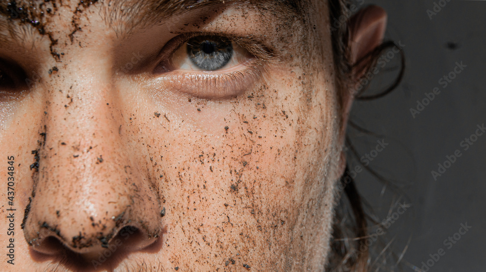 man with mud on his face. He looks with his colored eye. white background. man with mud on his face. He looks with his colored eye. white background.