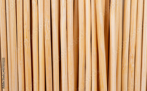 Multiple wooden bamboo skewers laying on white background macro