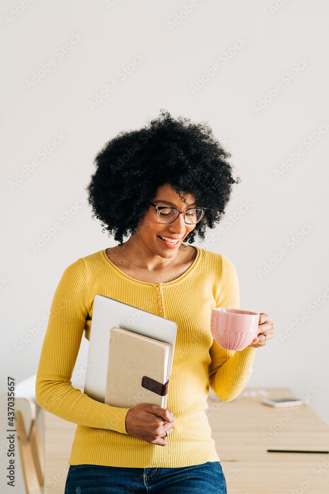 Black woman in eyeglasses with cup and notebook with laptop Black woman in eyeglasses with cup and notebook with laptop