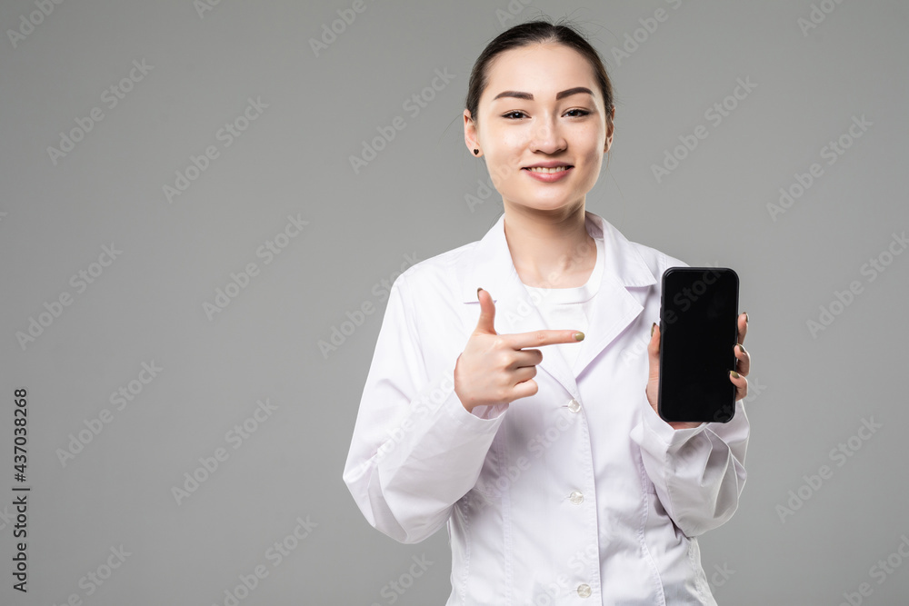 Asian female doctor smiling and showing a blank smart phone screen isolated on a white background Asian female doctor smiling and showing a blank smart phone screen isolated on a white background