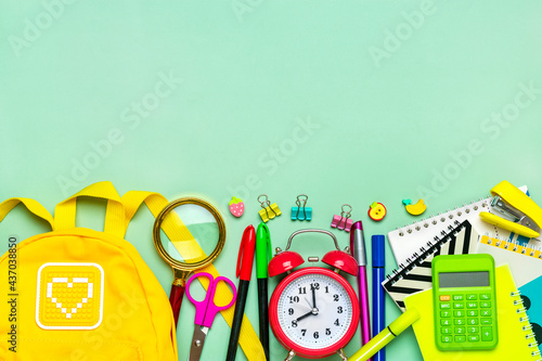 Frame from of office supplies Paper clips, scissors, pens, felt-tip pens, sharpener, calculator, stapler isolated on green background Flat lay Top view Back to school, education concept
