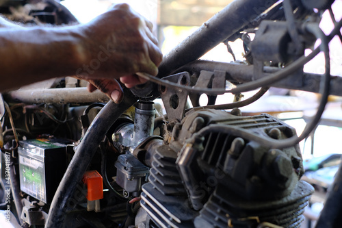 The motorcycle engine carburetor was repaired by a mechanic.