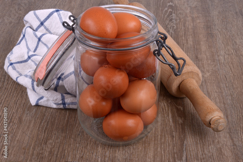 Bocal d'oeufs avec un rouleau à pâtisserie et un torchon sur un fond en bois photo