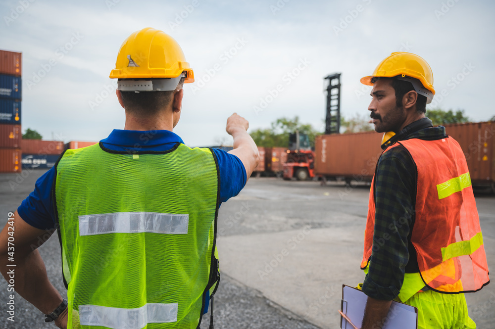 logistic worker teamwork and partner of foreman, engineer, and businessman working in an international shipping area, concept of business industrial and working in container yard to import and export logistic worker teamwork and partner of foreman, engineer, and businessman working in an international shipping area, concept of business industrial and working in container yard to import and export