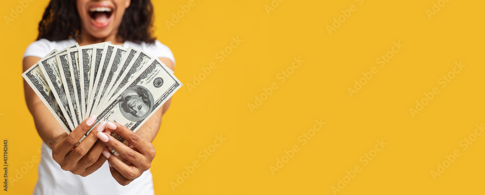 Cashback and wealth concept. African american lady holding money cash, standing over yellow background, panorama Cashback and wealth concept. African american lady holding money cash, standing over yellow background, panorama