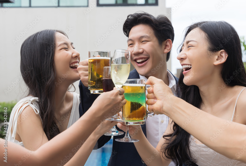 Young asian friends toasting drinks at a party Young asian friends toasting drinks at a party