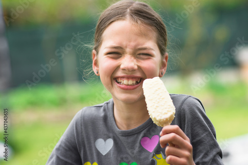 Child eating ice cream and make grimace. Holiday and summer concept. photo